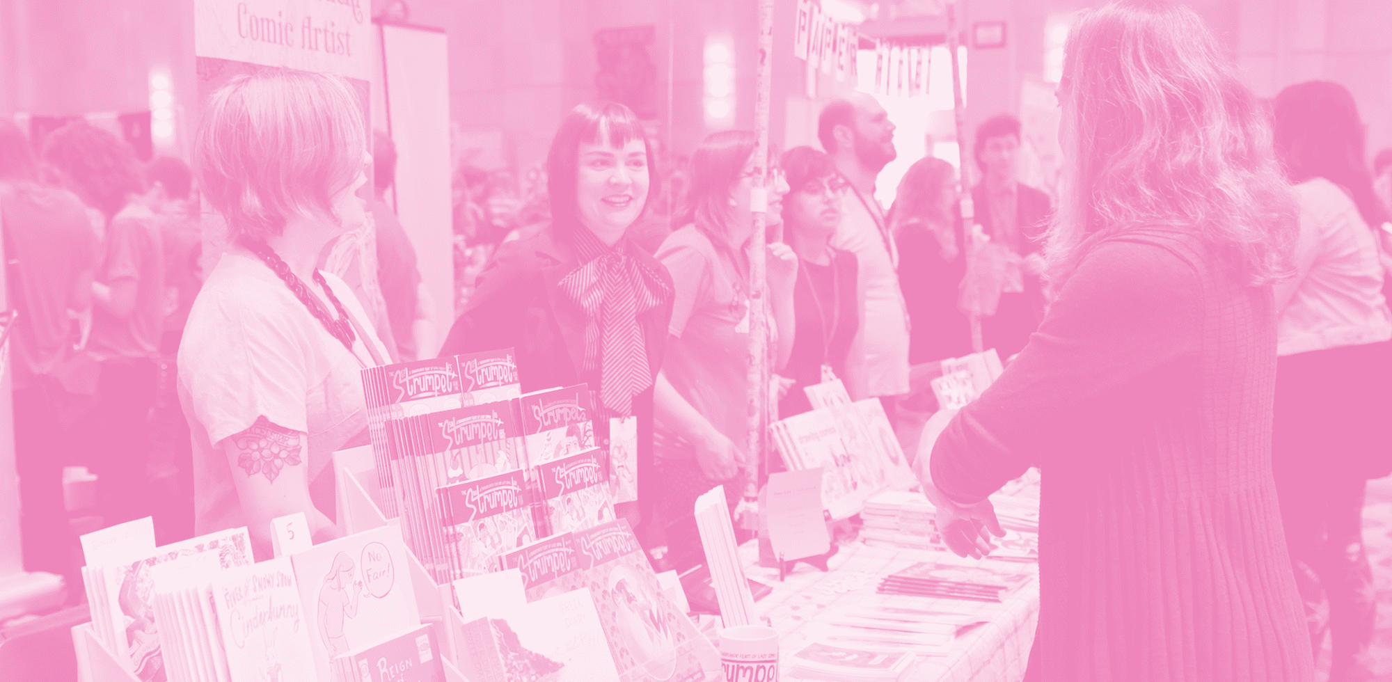 People standing behind a table at a convention
